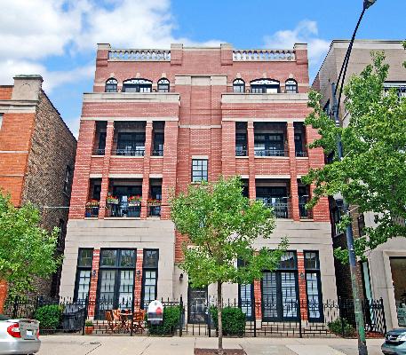 Front view of a multistory brick building with balconies.