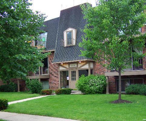 Front view of a multi-story residential building with a sloped roof.