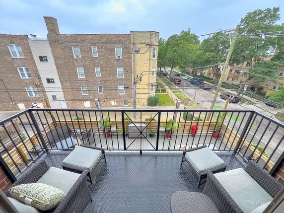 View of surrounding area from a balcony overlooking a residential street.