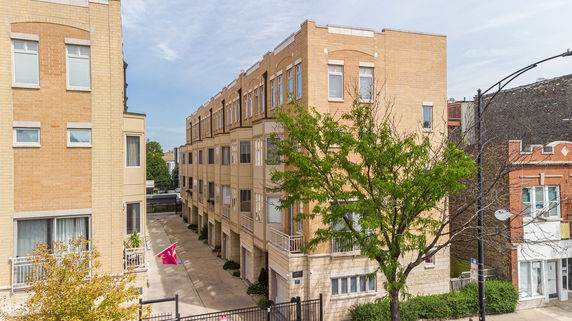 Front view of a multi-story building with beige brick exterior.