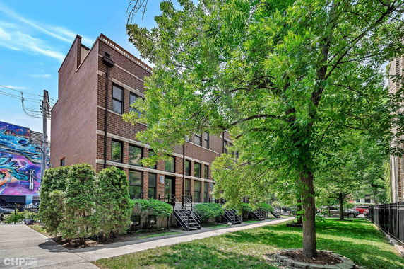 Front view of a multi-story brick townhouse with multiple entrances.
