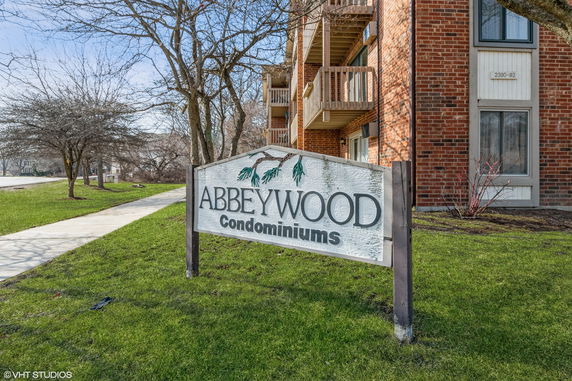 Front view of a brick condominium building with small balconies.