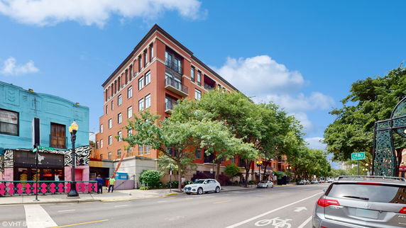 Front view of a multi-story brick building on a street corner.