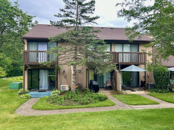 Front view of a two-story house with balconies and a brown exterior.