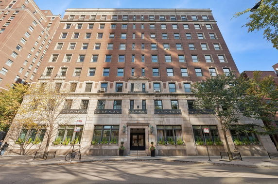 Front view of a multi-story brick building with numerous windows and decorative elements.
