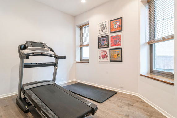 Indoor room with a treadmill and artwork on the walls.
