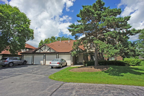 Front view of a multi-story house with an attached garage and driveway.