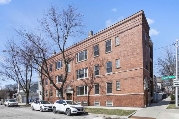 Front view of a brick three-story apartment building.