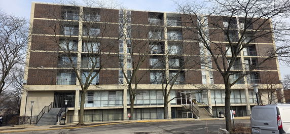 Front view of a multi-story apartment building with brick facade.