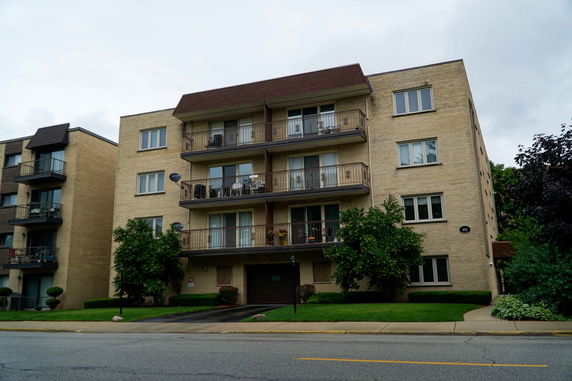 Front view of a multi-story apartment building with balconies.