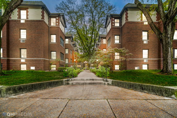 Front view of a multi-story brick building with a central walkway.
