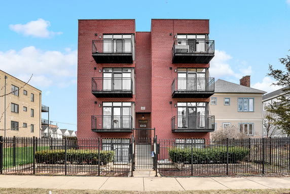 Front view of a multi-story brick building with balconies.