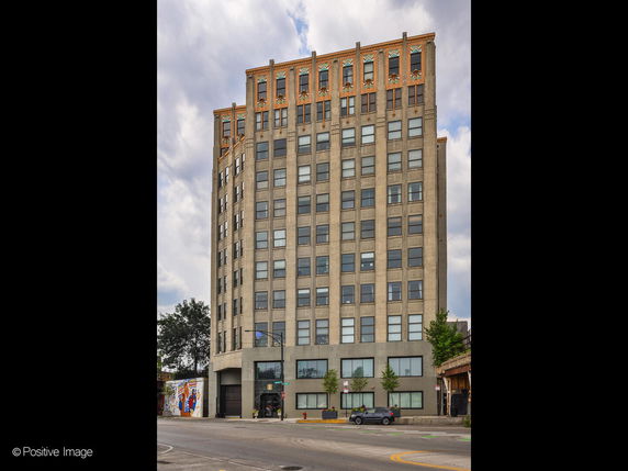 Front view of a multi-story building with a detailed rooftop design.