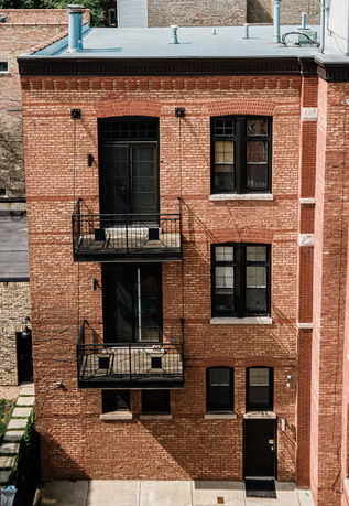 Front view of a multi-story brick building with balconies.