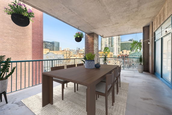 Terrace with dining table overlooking city skyline.