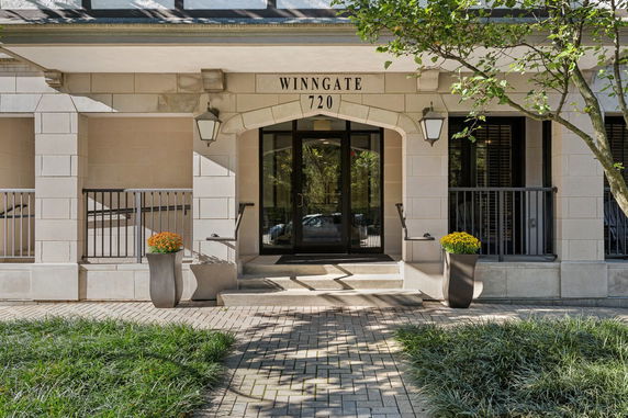Front view of a building entrance with columns and glass doors.