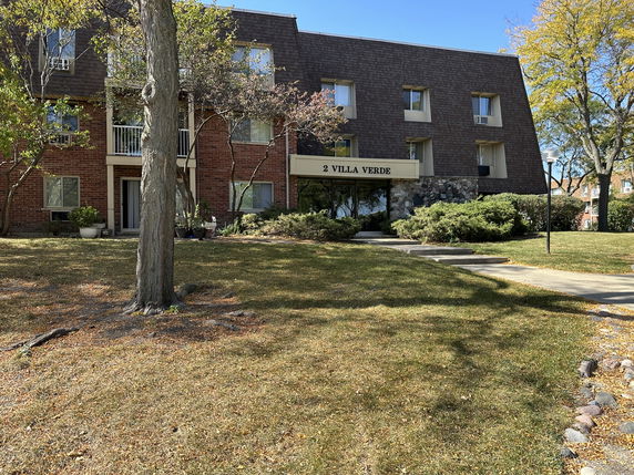Front view of a multi-story building with brown brick facade and several windows, labeled '2 Villa Verde'.