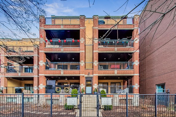 Front view of a multi-story brick building with balconies.