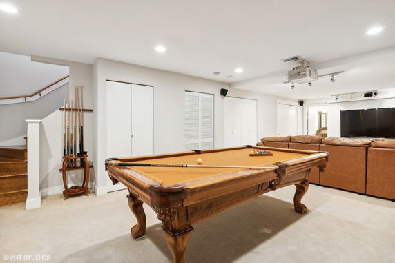 Room with a billiards table and a large sofa in a recreation area.