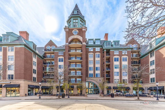 Front view of a multi-story residential building with a central tower and balconies.