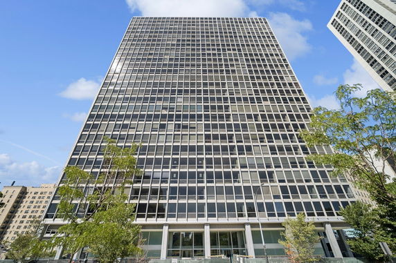 Front view of a tall office building with a grid glass facade.