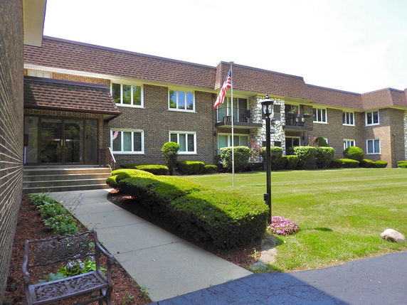 Front view of a two-story brick building with multiple windows and balconies.