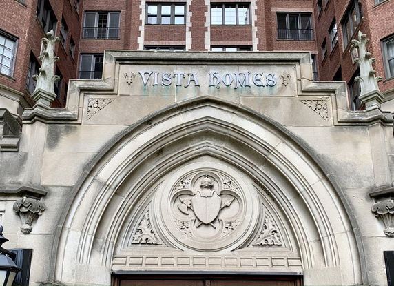Front view of a building entrance with an ornate arch and decorative elements.