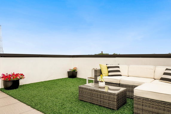 Rooftop with outdoor seating area and artificial grass.