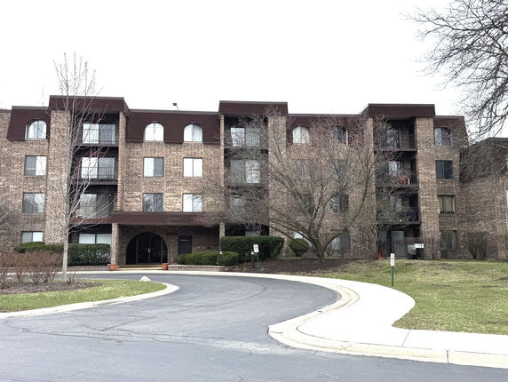 Front view of a multi-story brick apartment building.