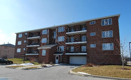 Front view of a multi-story brick apartment building.