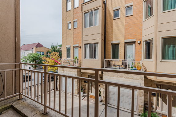 Balcony view of neighboring multi-story residential buildings with garages.
