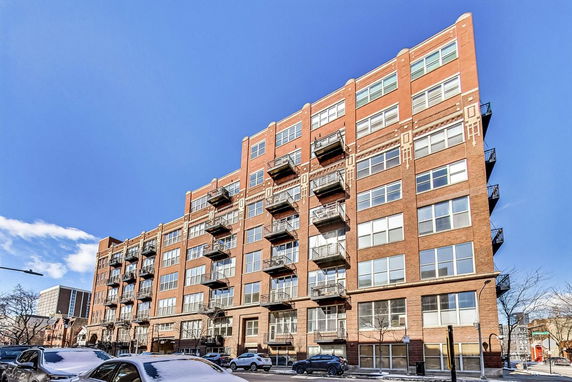 Front view of a multi-story brick building with balconies.