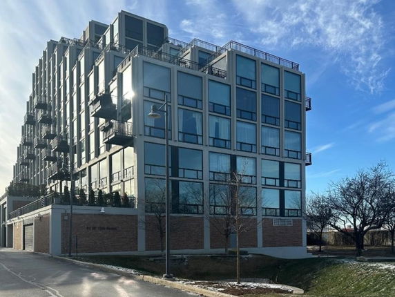 Front view of a modern multi-story building with large windows and balconies.