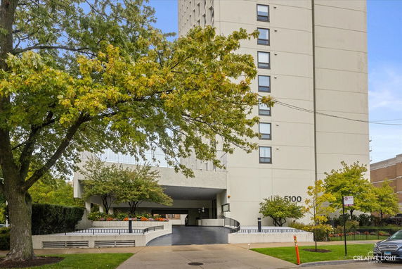Front view of a multi-story building with a driveway entrance.