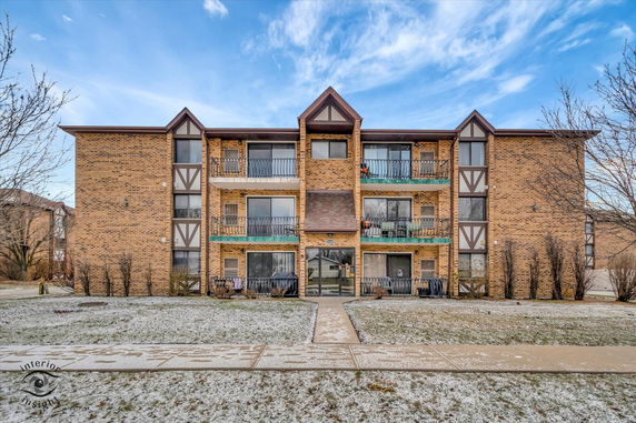 Front view of a multi-story brick building with balconies.