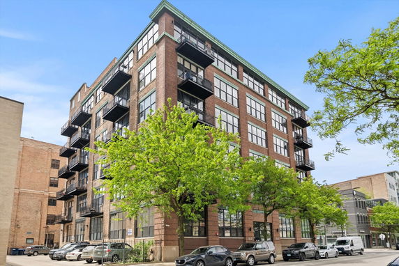 Front view of a multi-story apartment building with balconies.