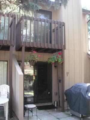Front view of a two-story house with a small balcony and patio area.