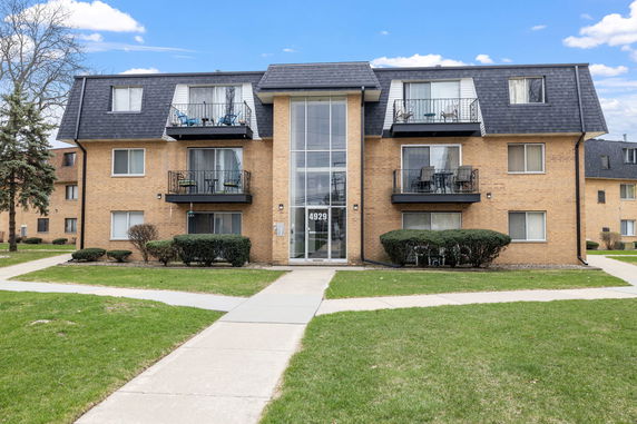 Front view of a two-story brick apartment building with balconies.