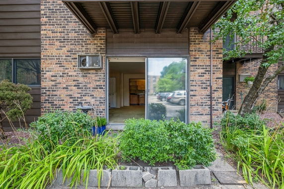 Front view of a building with brick exterior and a sliding glass door.