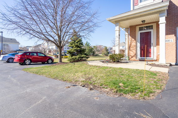 Front view of a house with a red door and porch.