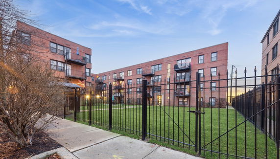 Front view of multi-story brick apartment buildings with balconies.