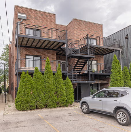 Front view of a brick apartment building with balconies.