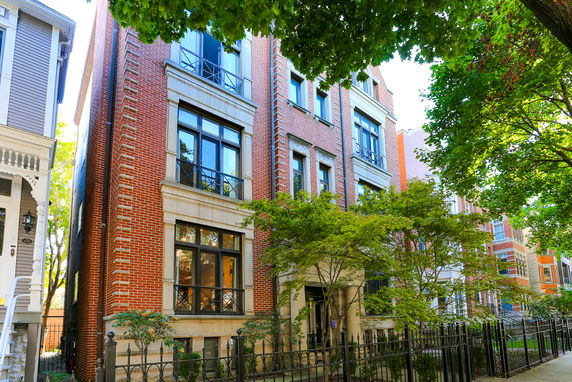 Front view of a multi-story brick building with large windows.