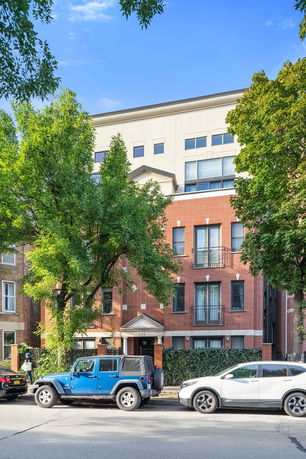 Front view of a multi-story brick building with large windows.