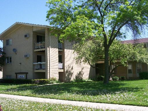 Front view of a multi-story apartment building with balconies.