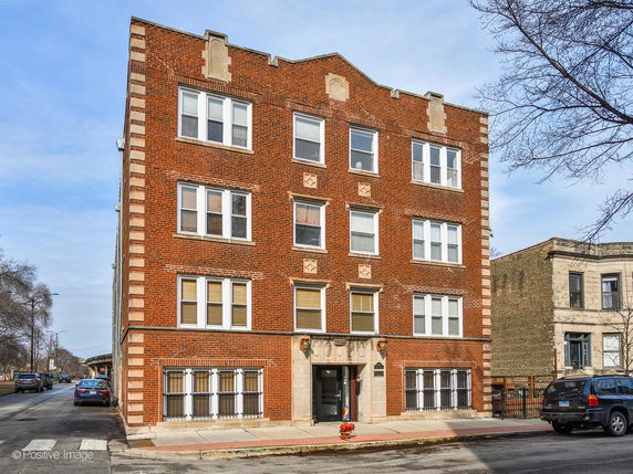 Front view of a multi-story brick building with multiple windows.
