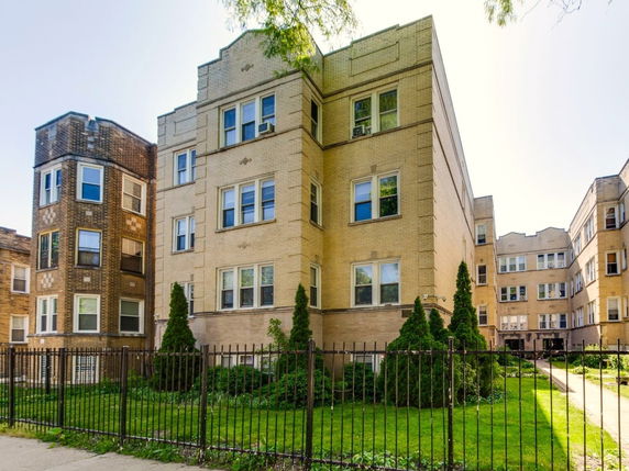Front view of a multi-story apartment building with brick exterior.