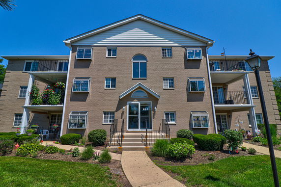 Front view of a multi-story apartment building with balconies.