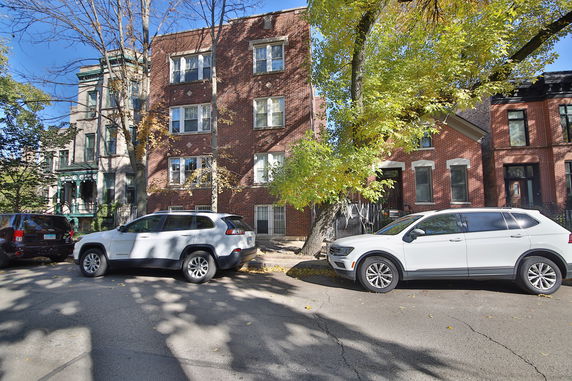Front view of a four-story brick apartment building.