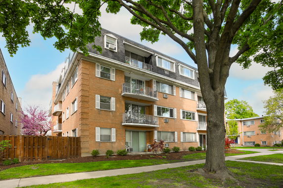 Front view of a multi-story brick apartment building.